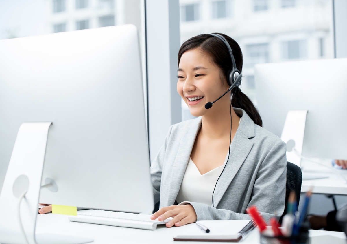 Woman wearing microphone headset working in call center office